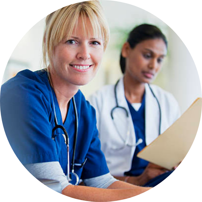 Two nurses, one of them is smiling and the other is looking at a clipboard