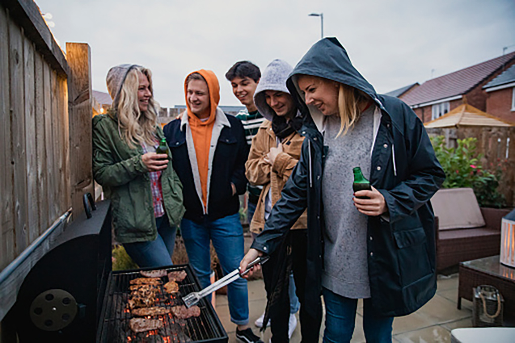Group of people having a barbecue together drinking alcohol