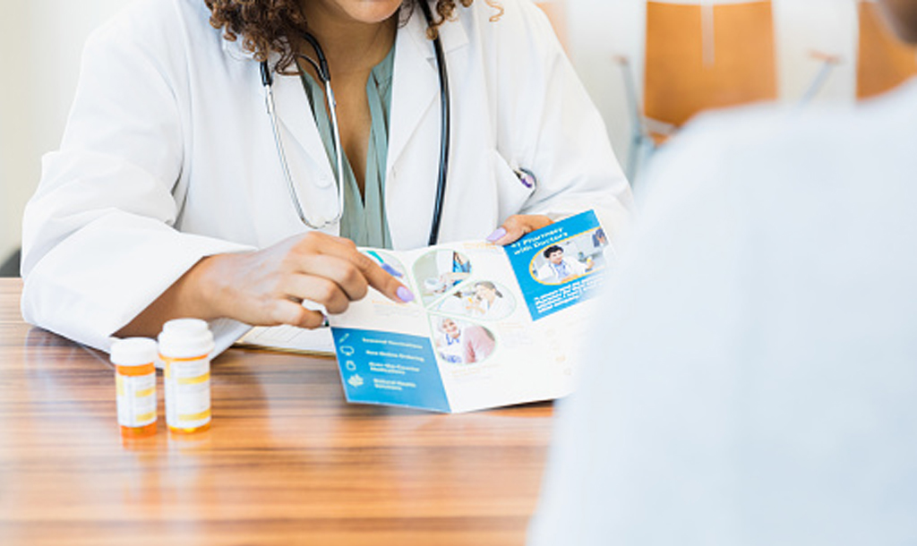 a doctor showing a epilepsy treatment leaflet to their patient