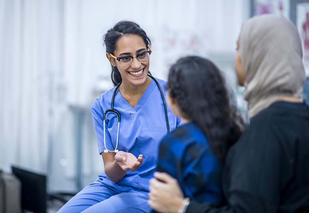 Female doctor talking to a mother and daughter Female doctor talking to a mother and daughter