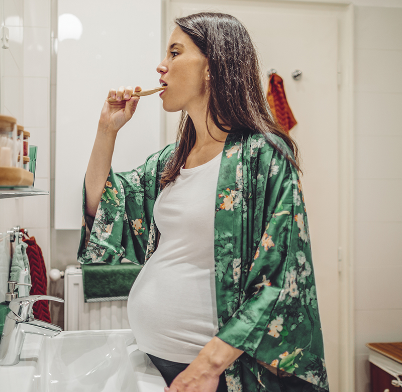 A pregnant woman brushing her teeth