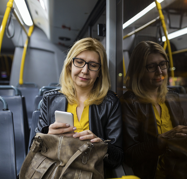 Woman looking at her phone whilst riding public transportation