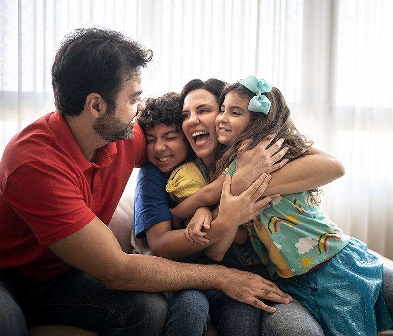 Parents and children embracing at home