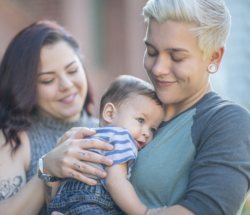 Same sex couple holding their baby