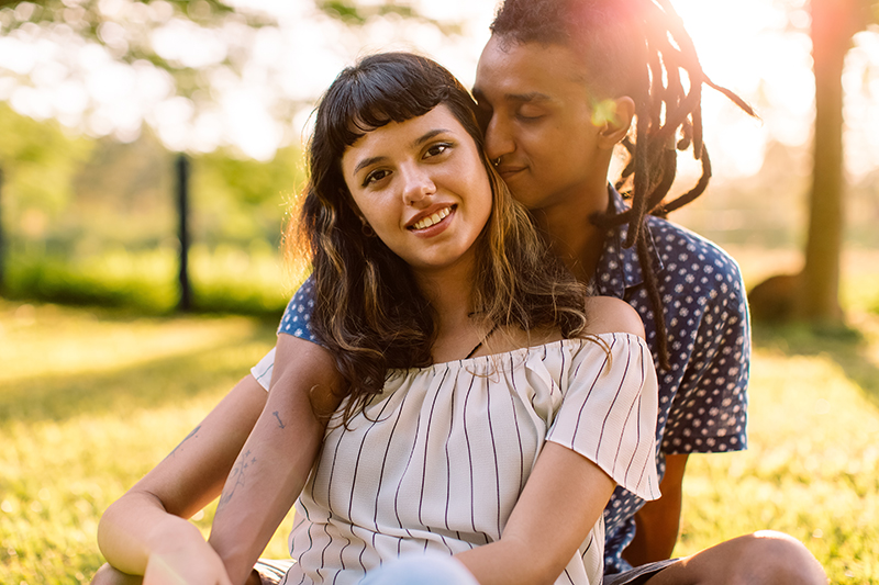 Two young lovers being romantic in a park