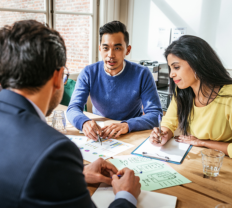 a group of three people in a meeting