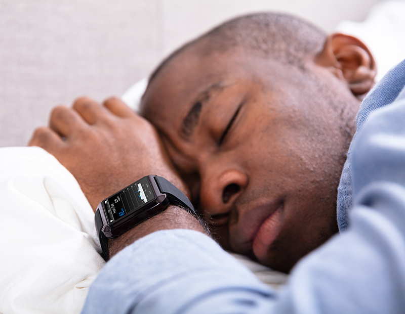 A man sleeping using epilepsy safety equipment on a watch