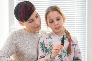 Woman and young girl looking at a medical cannabis product