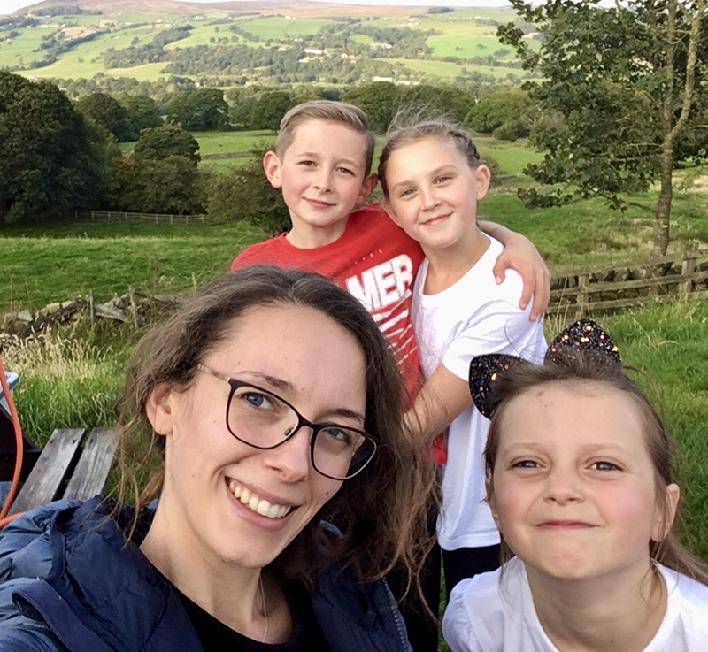 Leona smiling with her kids on a countryside walk
