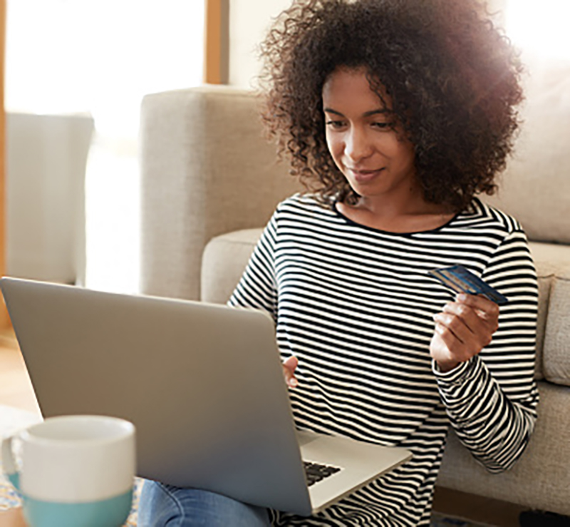 Shot of a young woman using her credit card to make an online payment