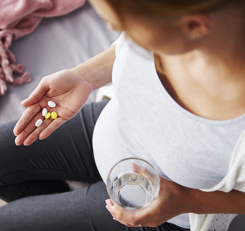 A pregnant woman taking medicine