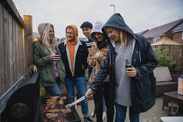 a group of friends enjoying a barbecue in the rain