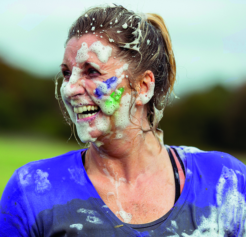 A woman with face covered in foam at a charity event