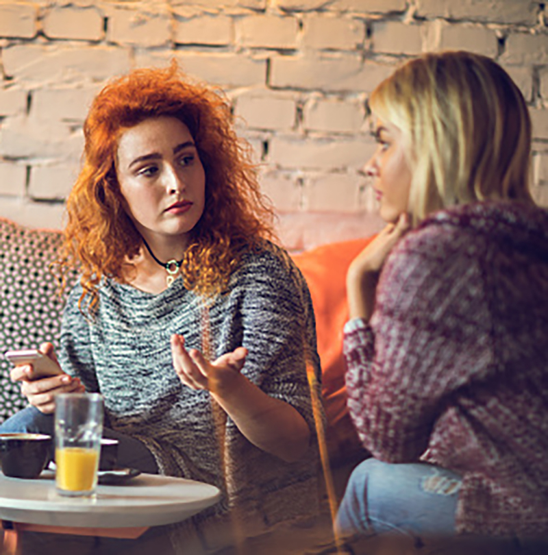 Two young women talking to each other in a café
