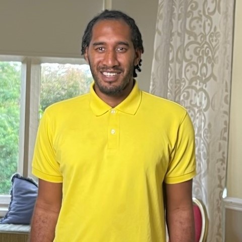 Man in yellow shirt smiling