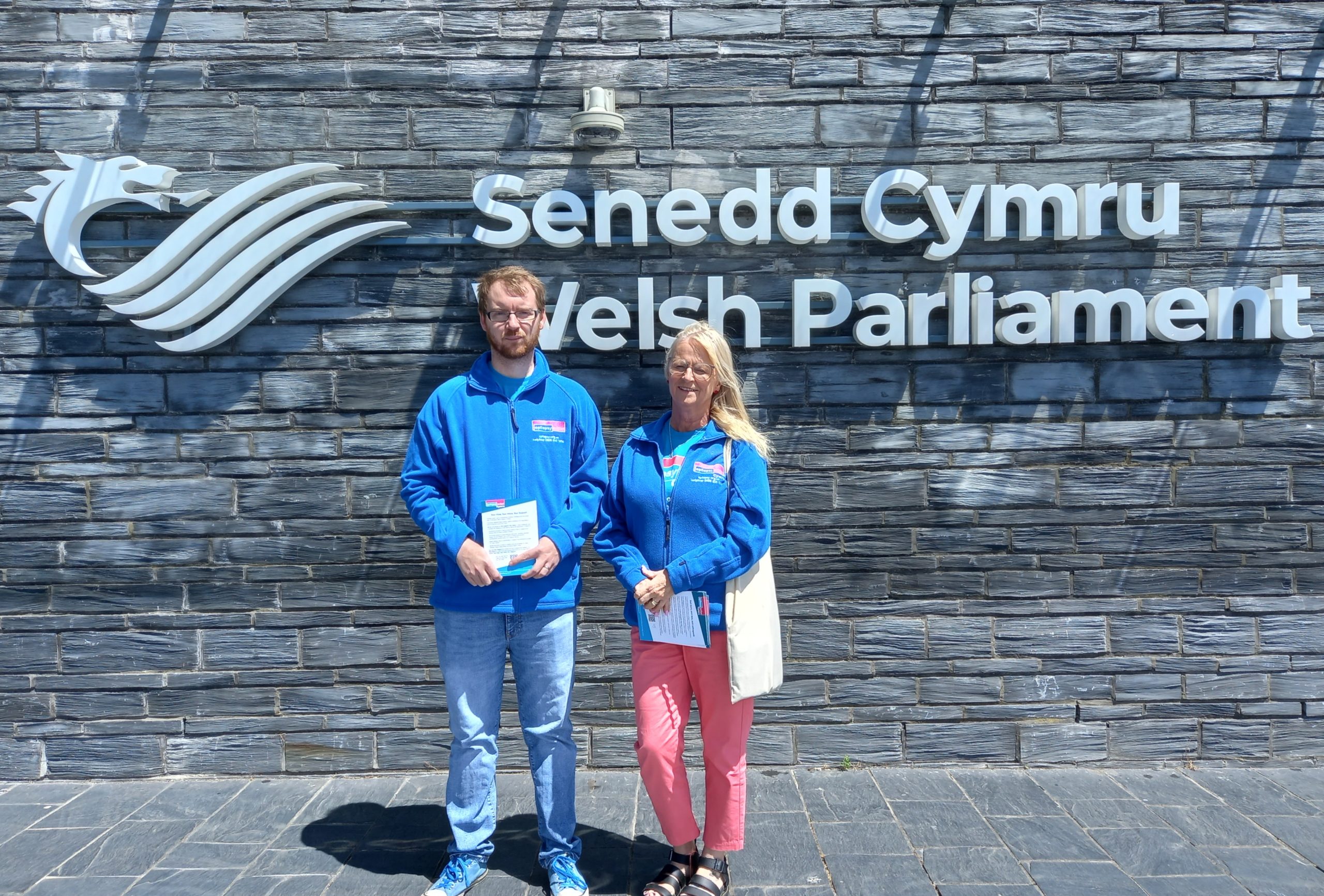 Man and woman standing in front of Welsh Parliament