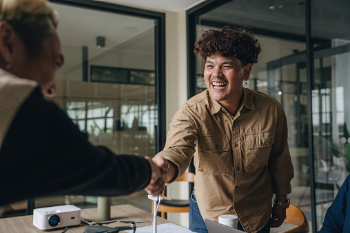 Man shaking hands with another professional in the office.