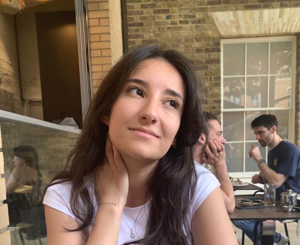 Image of Leti, a young woman with long brown hair and a white top