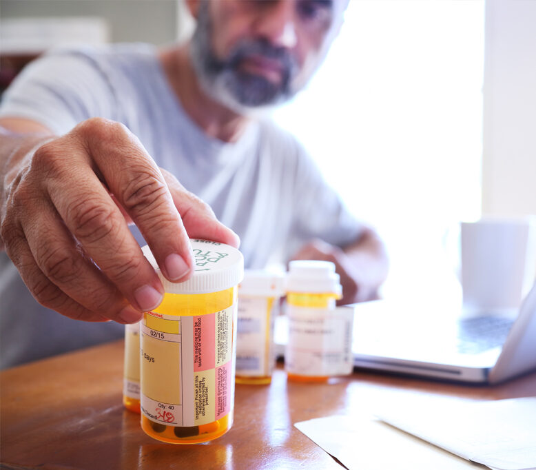 A man looking at a container of epilepsy medicine