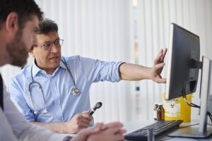 Doctor discussing findings from computer with colleague