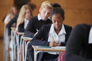 Teenagers sitting at desks taking exams