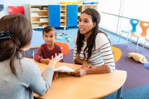 An attentive mother listens as her son's epilepsy needs during parent teacher conference