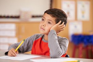 Portrait of a boy possibly having an absence seizure in class