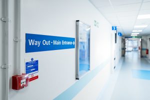 Way Out and Main Entrance sign seen within a typical NHS hospital