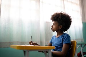 Girl in a classroom possibly having an absence seizure