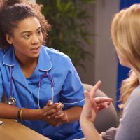 A nurse sitting with a patient