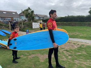 Max and John carrying surf boards