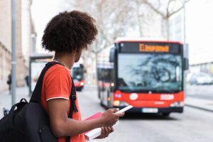 Anonymous black male student waiting for bus on street