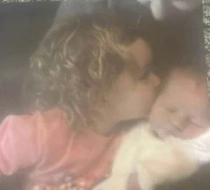 Mia-rose as a child giving baby lily a kiss