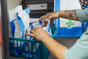 Pharmacist's hands looking through prescriptions in their bags