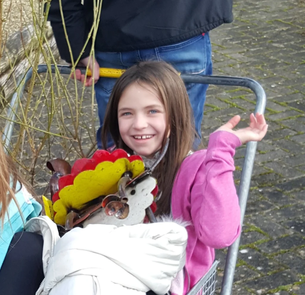 Ruby Waterman smiling and waving in a purple jacket