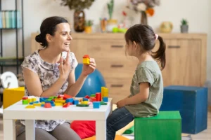 Autism and epilepsy: a young girl at an assessment with a health professional and colourful blocks