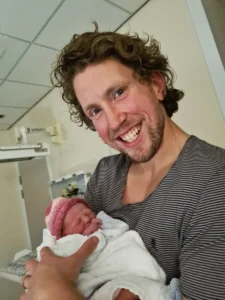 Ashley holding baby Penelope, who shared his story of creating an app to support people with epilepsy for Father's Day