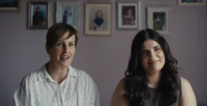 Two women sat together, one a bit older with a pixie cut and brown hair and one with a black top and long dark brown hair. HSBC employee Emma on the left, Ruby on the right.