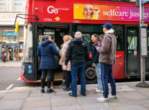 Free bus travel all day: a queue of people getting on a london bus