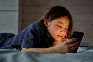 Young asian girl watching social media videos about epilepsy on her bed