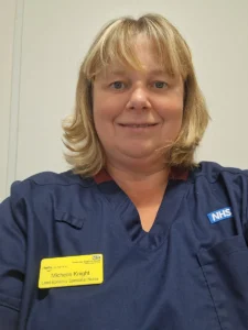 Michelle knight - nurse with blonde hair and dark blue nurse's uniform smiling