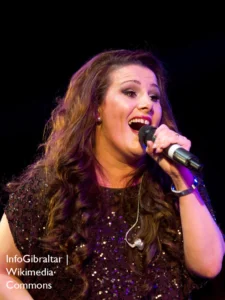 Sam bailey singing and holding a microphone